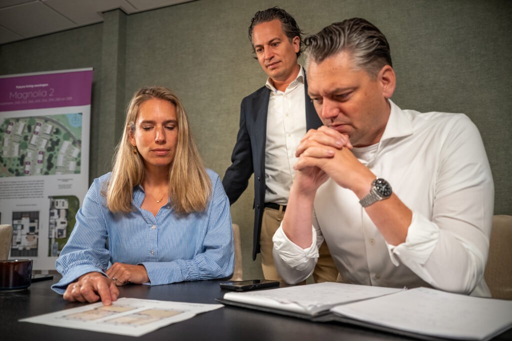 Adviseurs van Kocken Makelaars bekijken samen plattegronden van een woning aan tafel voor een energiescan