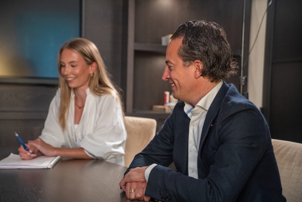 Adviseur van Kocken Makelaars in gesprek met een klant over haar hypotheek aan tafel op kantoor