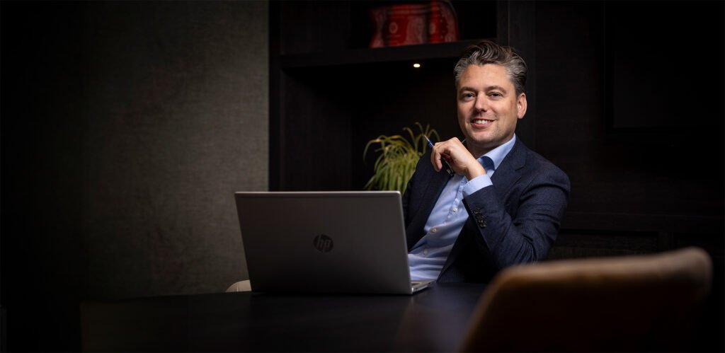 Taxateur van Kocken Makelaars zit met een laptop aan tafel op kantoor in Purmerend
